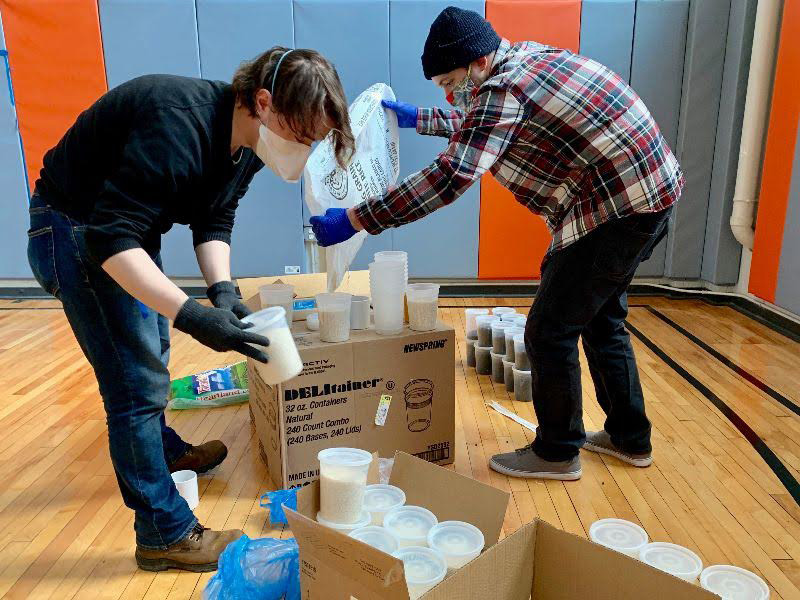Two people packaging rice to giveaway.